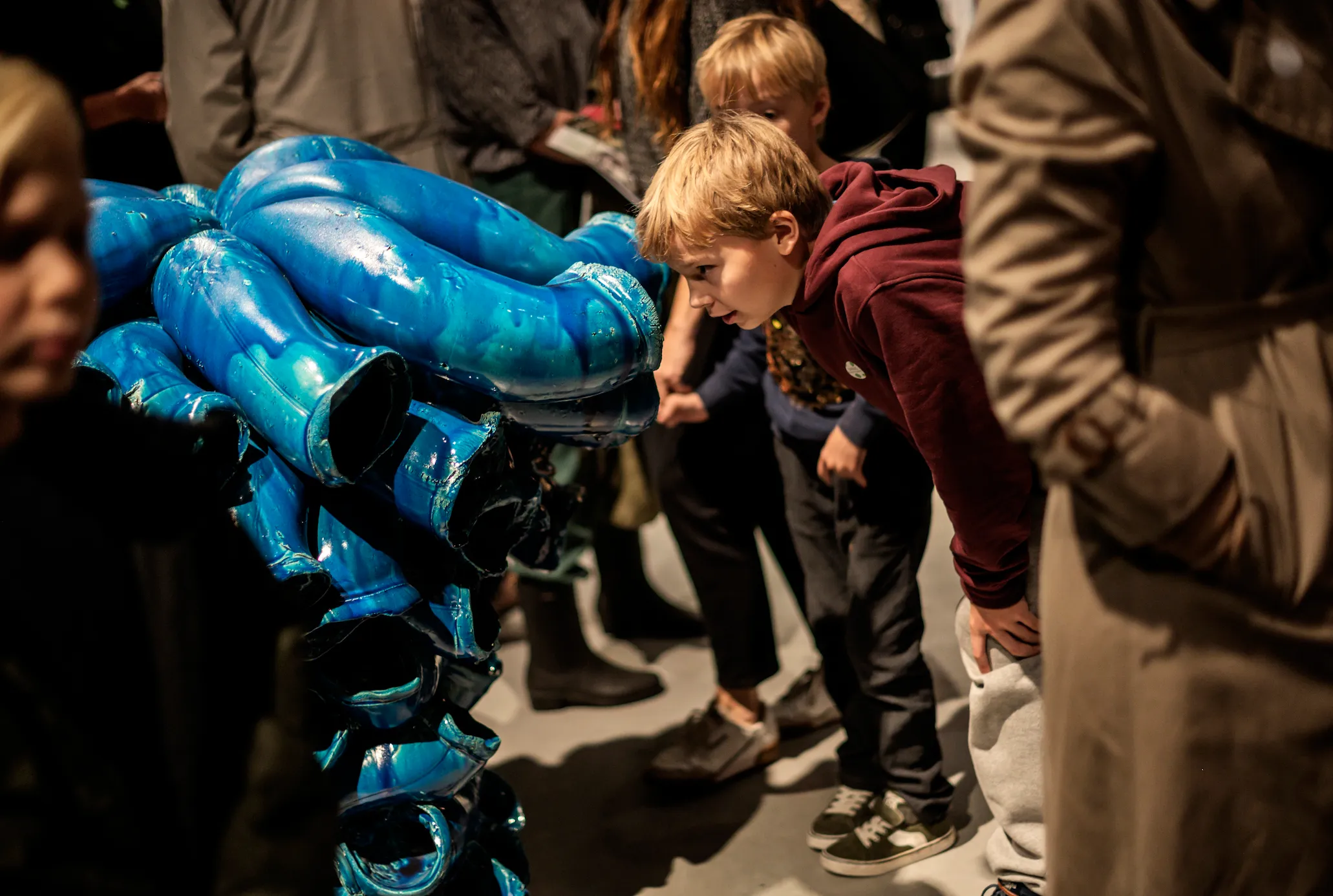 Gutt som ser på skulptur