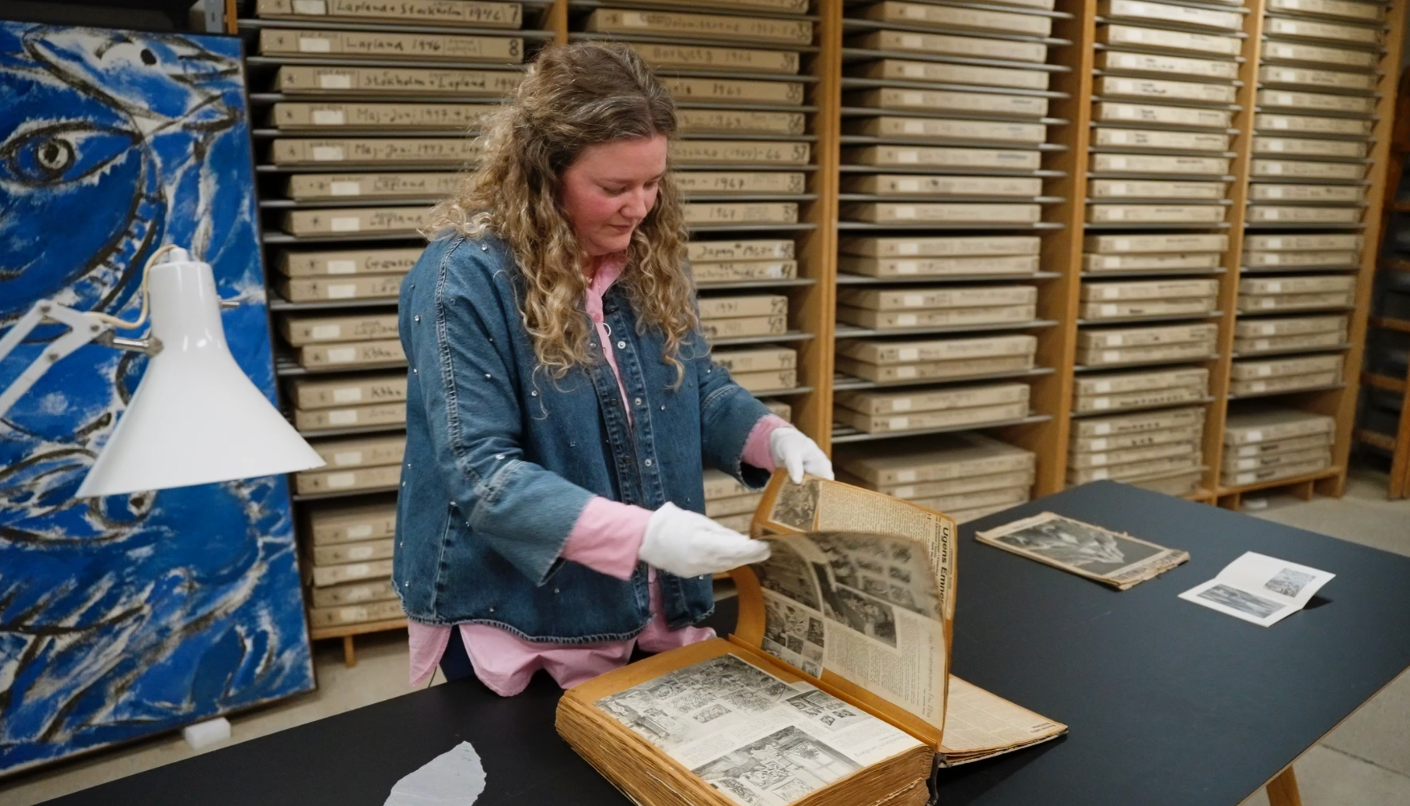 Kunsthistoriker som ser på gamle bilder og utklipp av kunstnerne Else Alfelt og Carl-Henning Pedersen