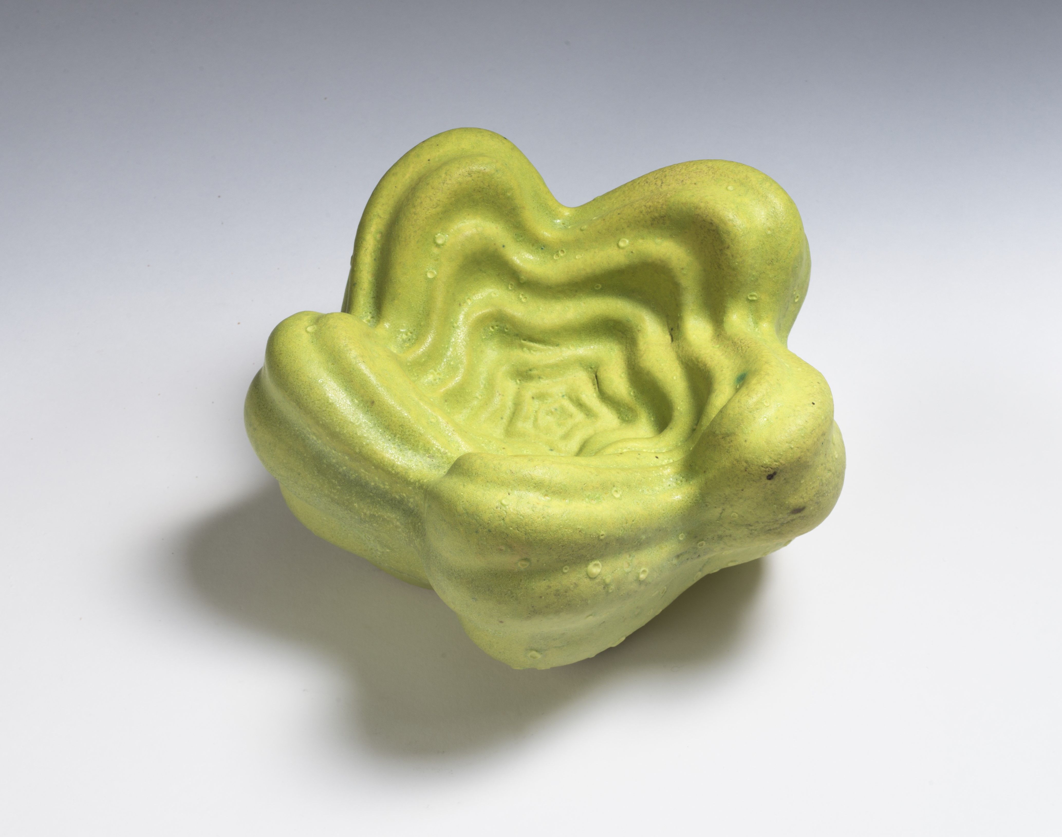 En liten grønn skulptur formet som en blomst