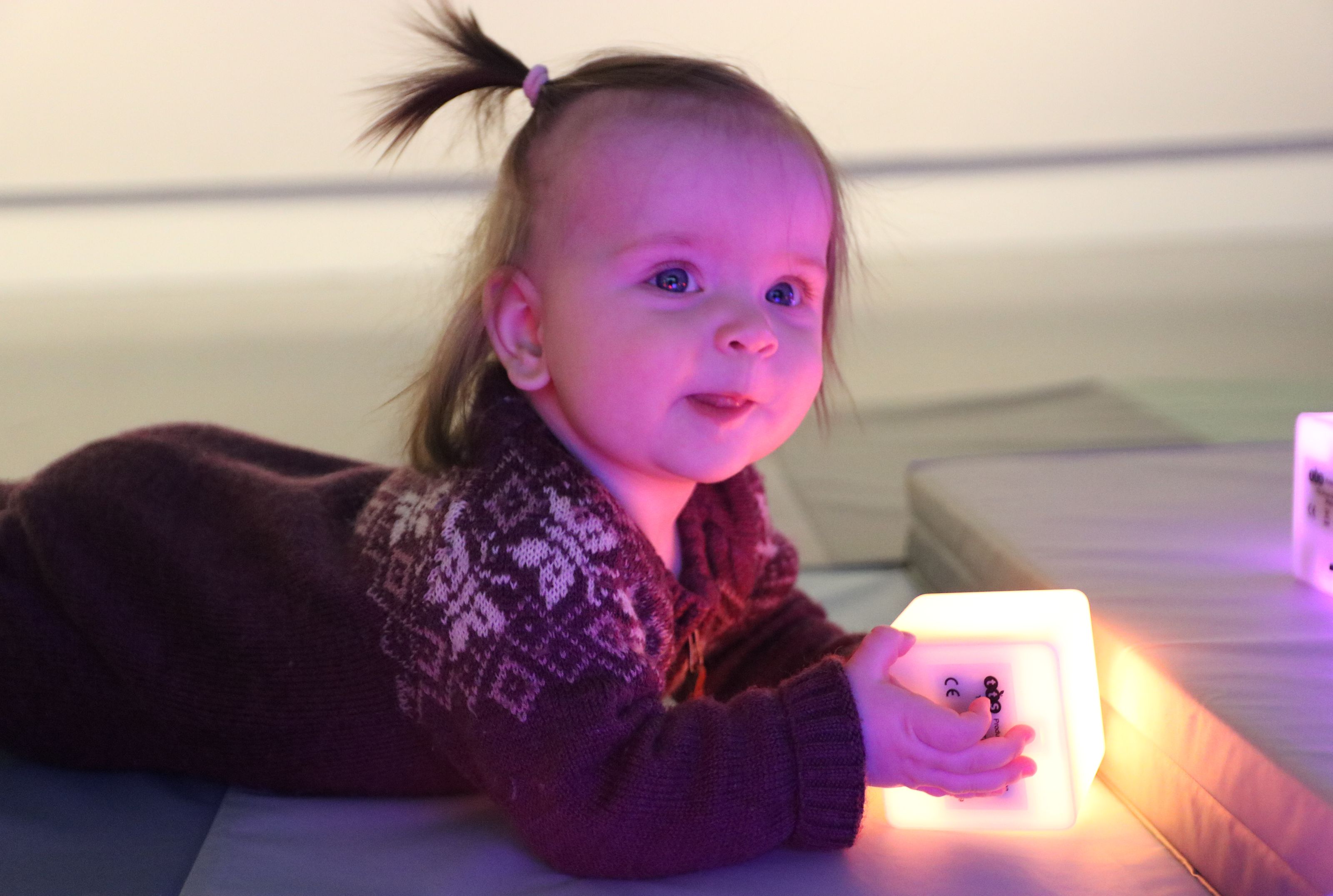 Baby holding a glowing cube