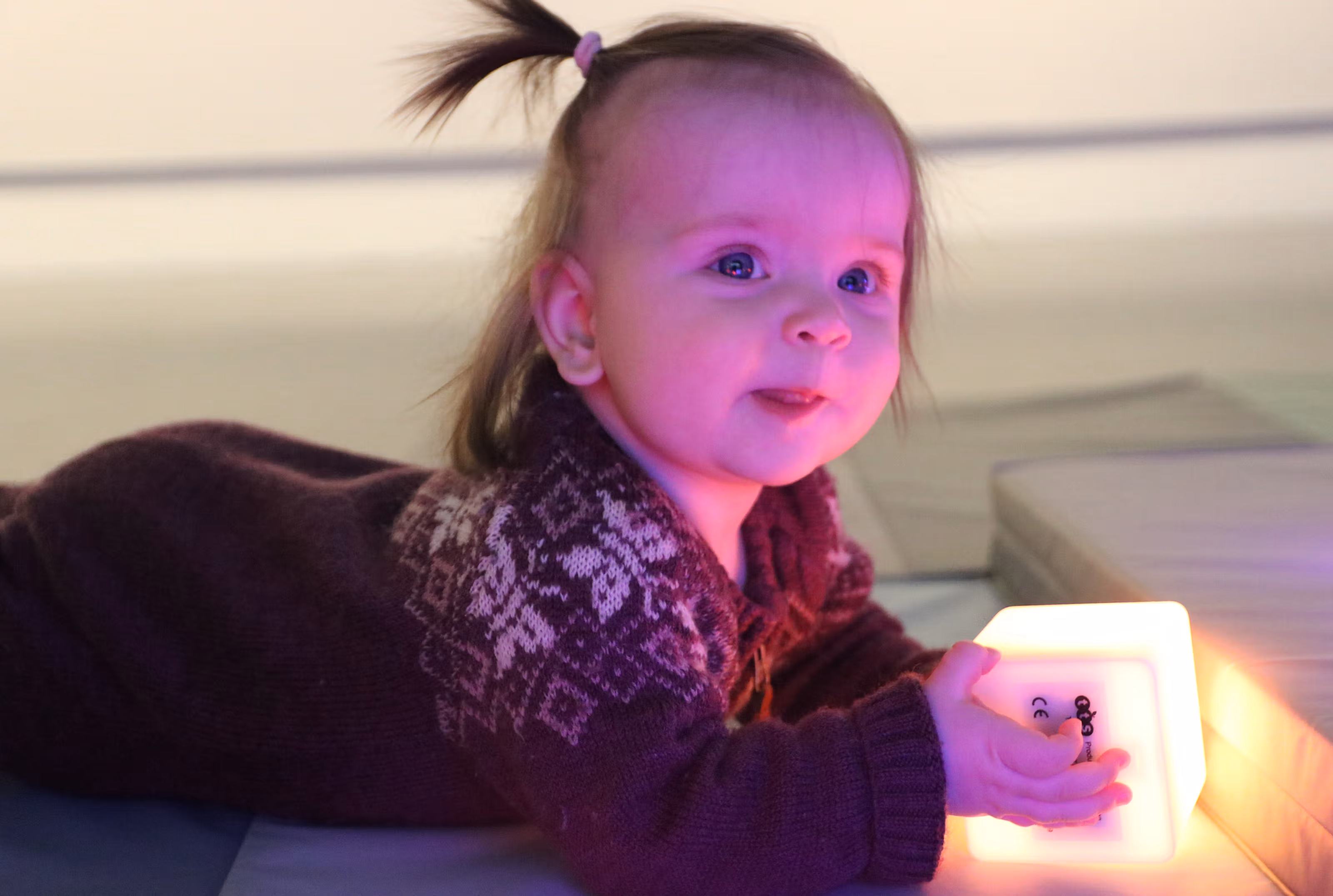 Baby som holder på en lysende firkant