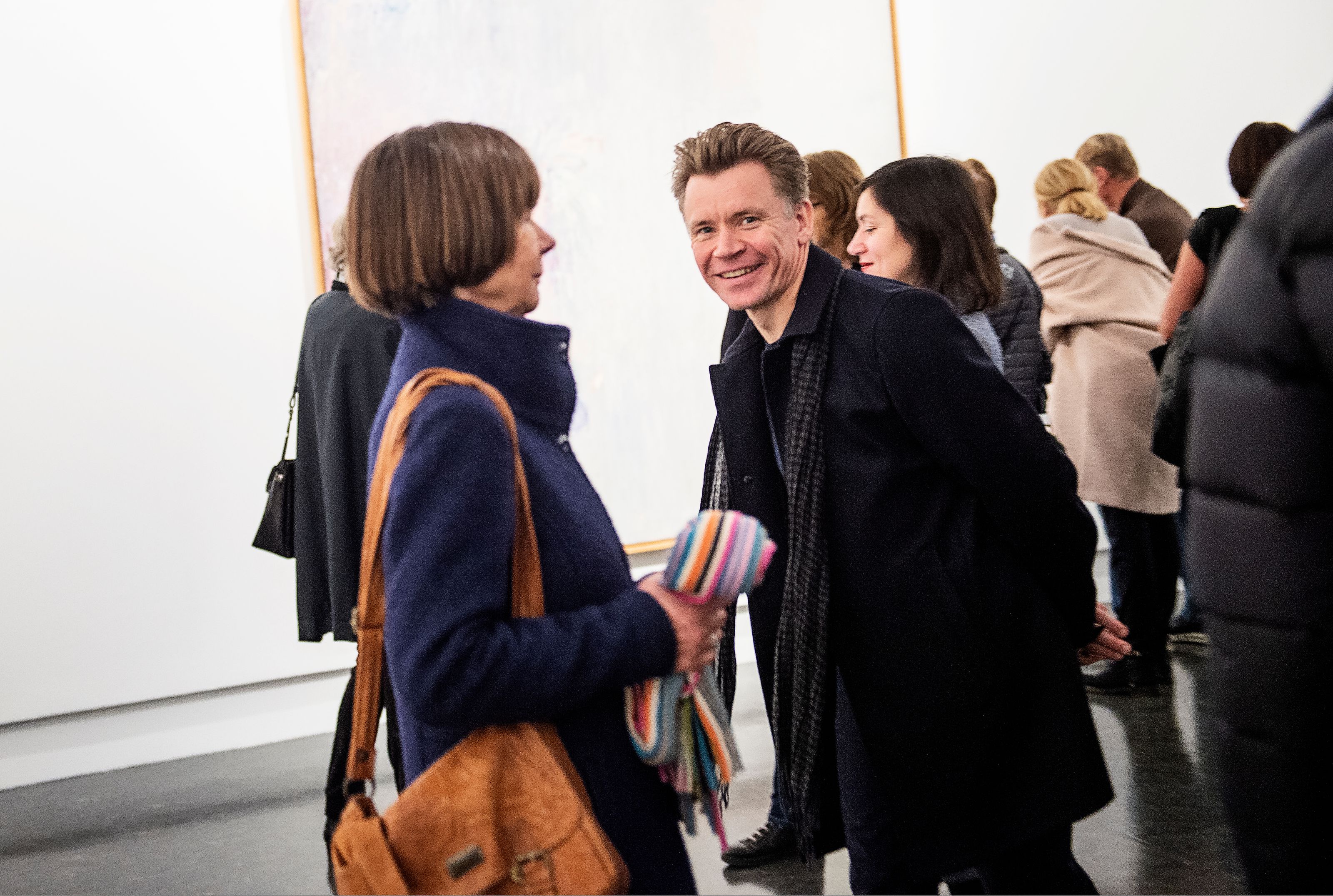 To personer står og ser på kunst i et mørkt galleri