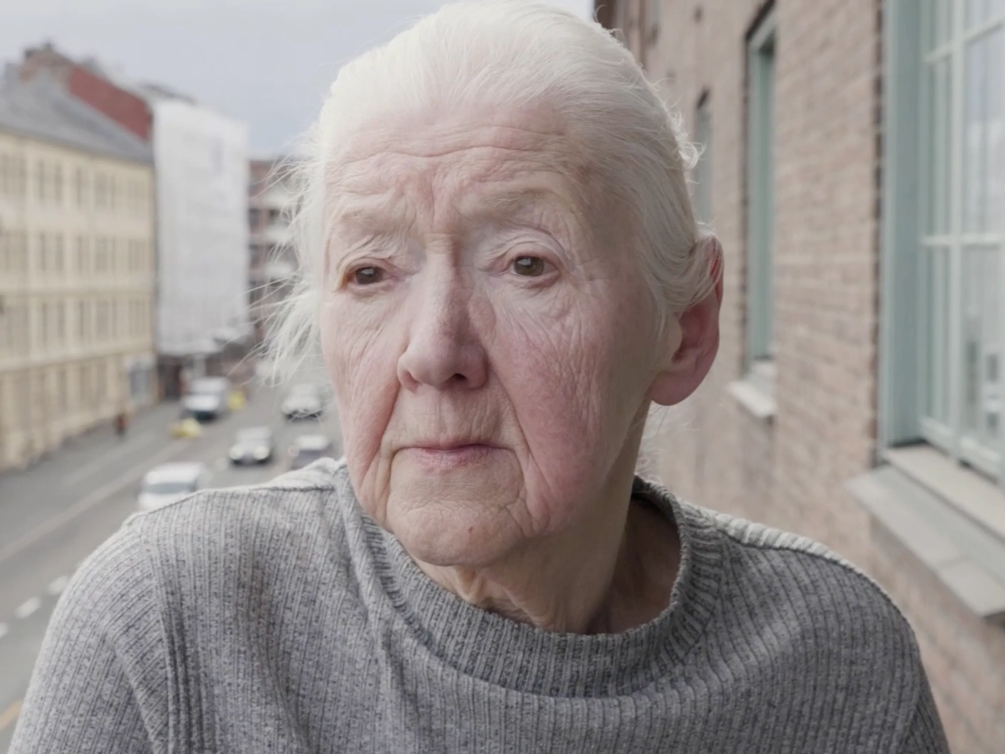 Zdenka Rusova ser utover Oslos gater fra balkongen sin
