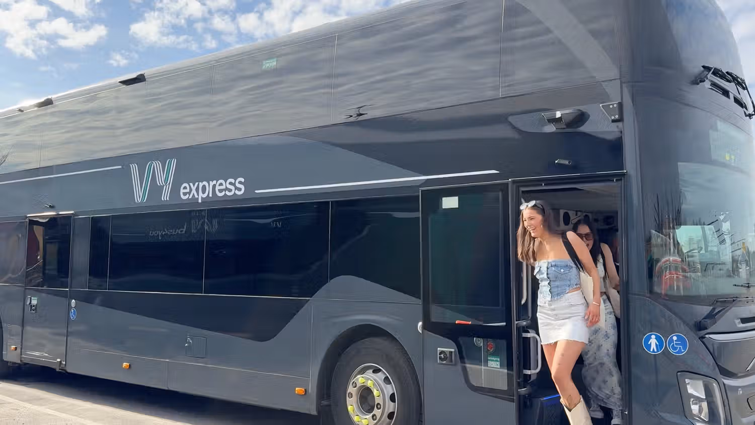 Blid jente som kommer ut av en VY-buss